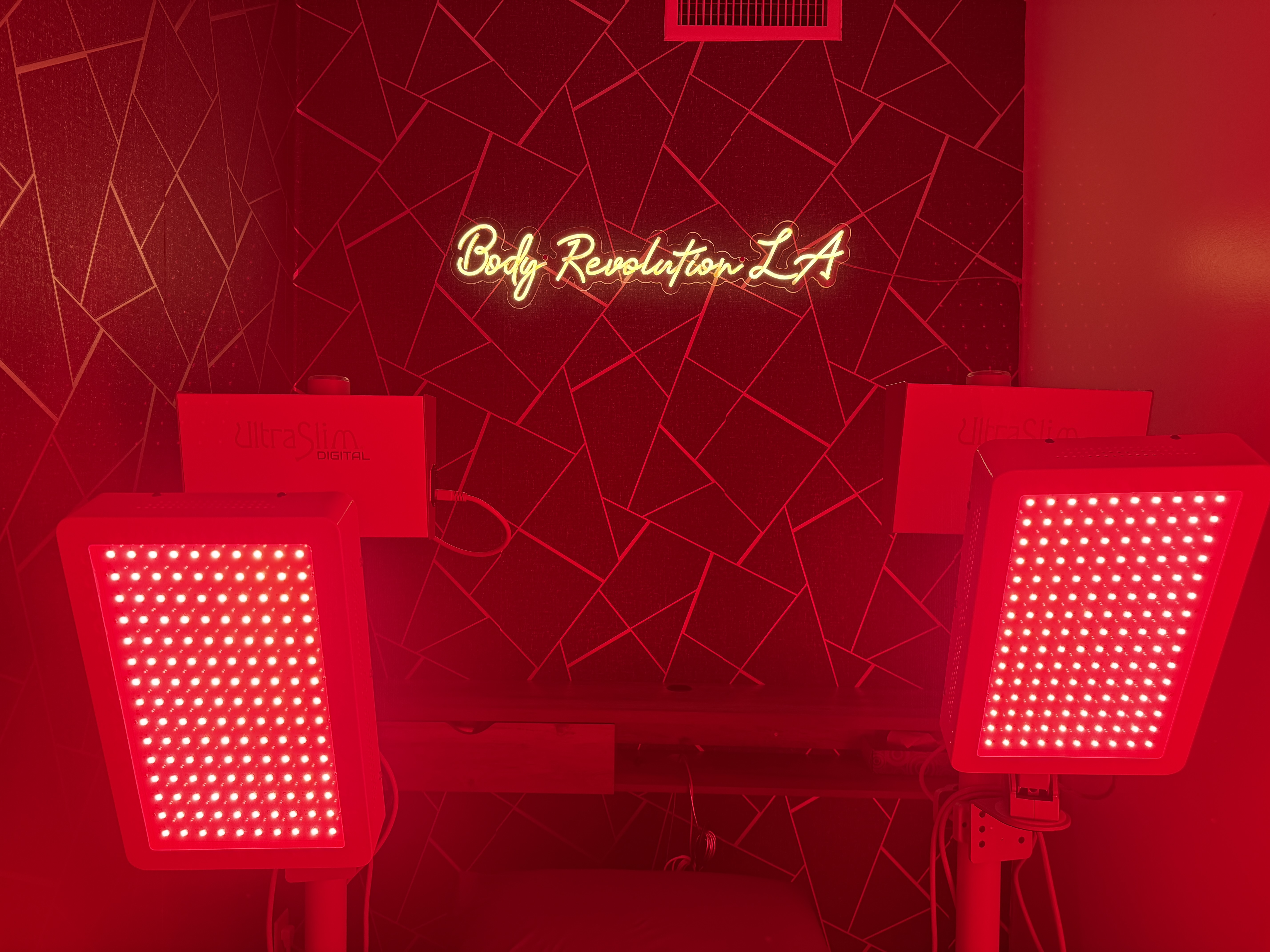 Body Revolution LA therapy room with LED panels and neon sign
